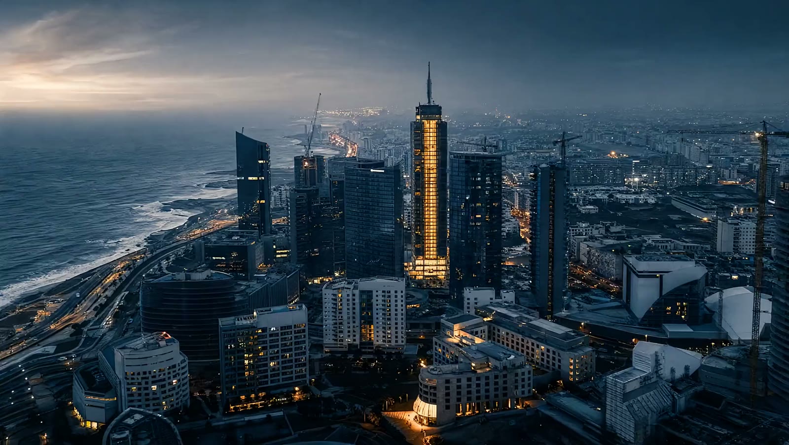 Quartier d’affaires de Casablanca vu du ciel, avec sa tour éclairée au bord de l’Atlantique.