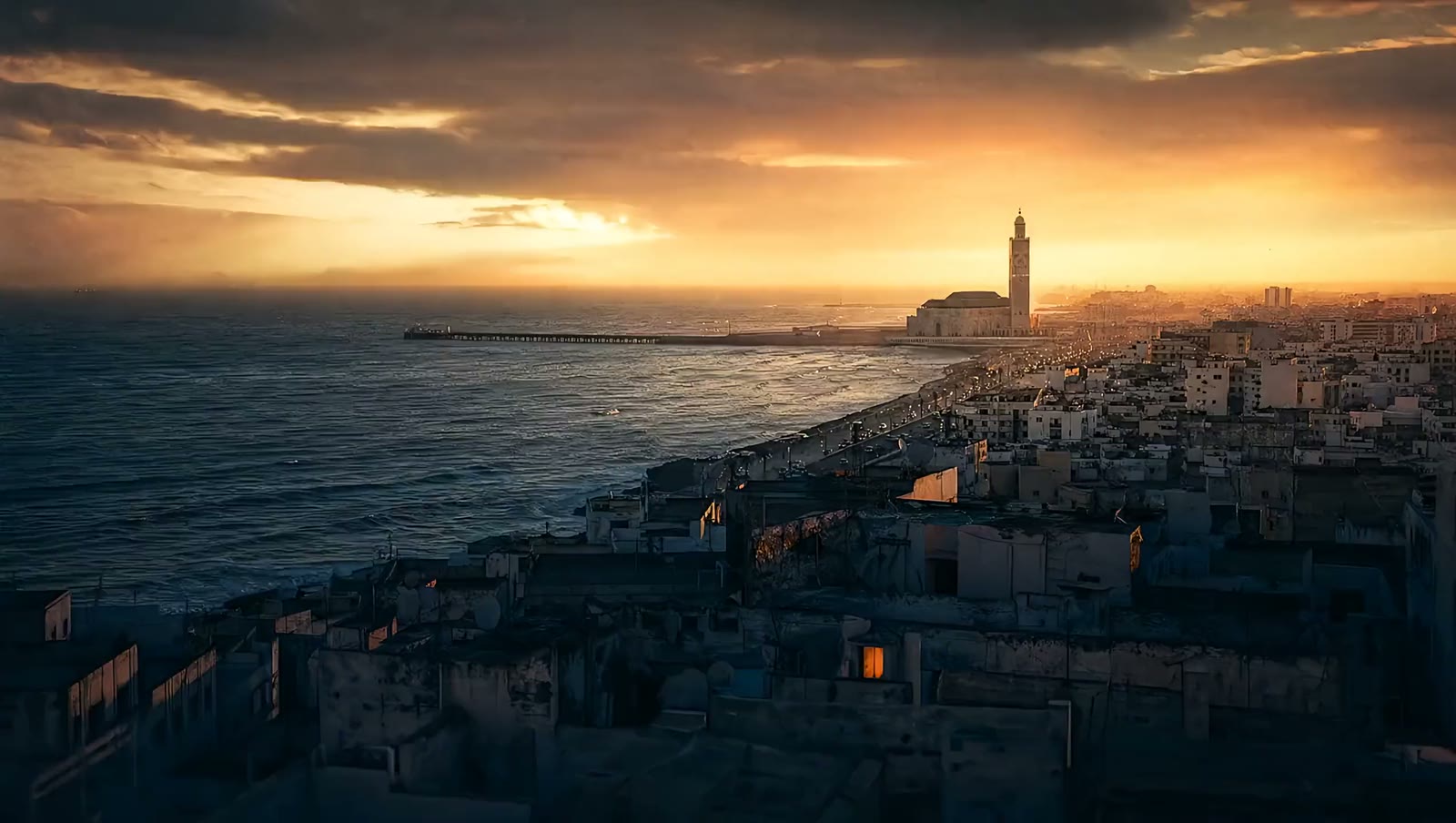 Casablanca et la mosquée Hassan-II au coucher du soleil, vues depuis la côte.